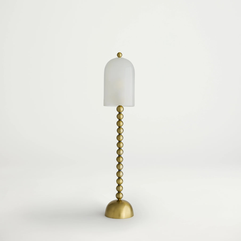 Gold floor lamp with a white shade on a light gray background
